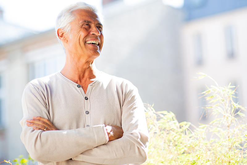 older man crossing his arms and smiling